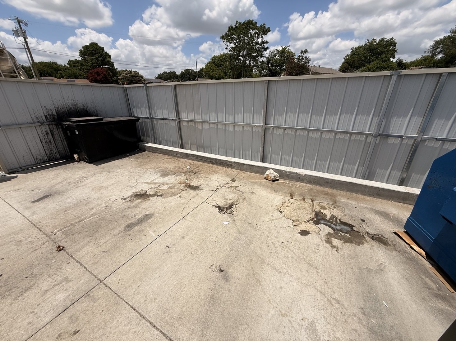 Clean dumpster enclosure after junk removal